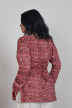 Person wearing a red patterned outfit on a plain background